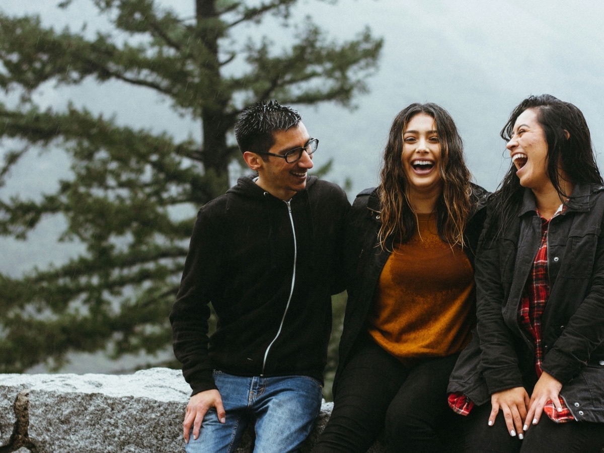 Three friends walking and laughing together outdoors